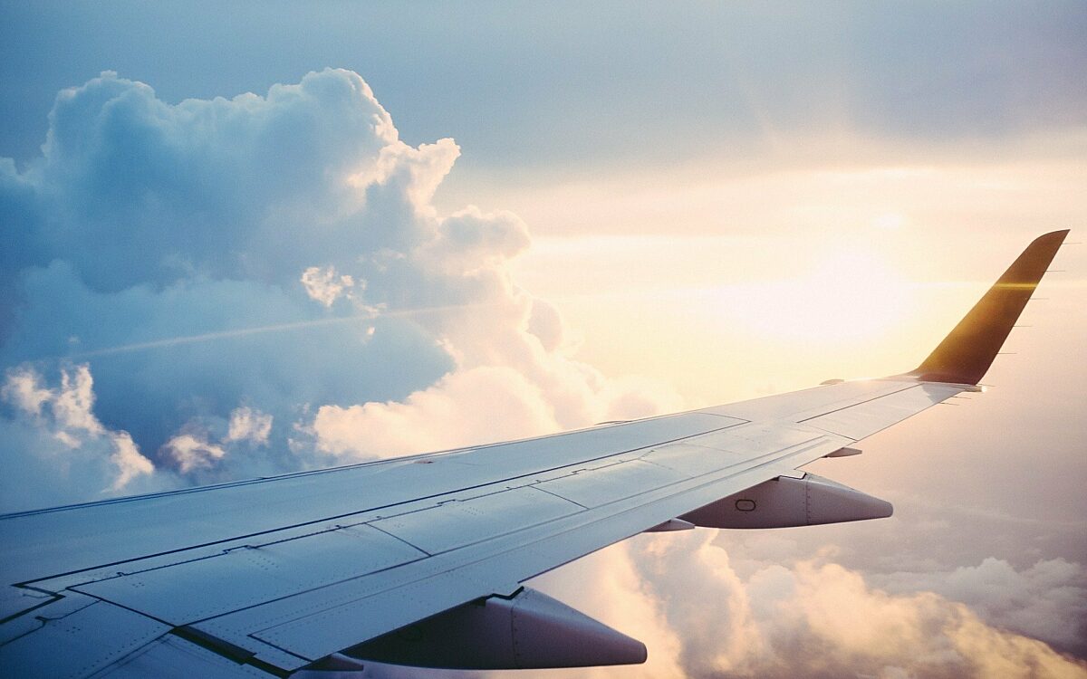 Flugzeug schwebt über den Wolken und die Sonne strahlt am Flügel der Maschine Flugzeug schwebt über den Wolken und die Sonne strahlt am Flügel der Maschine